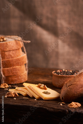 Traditional Dutch semi hard cheese served close up on rural table with sacking. Selective focus