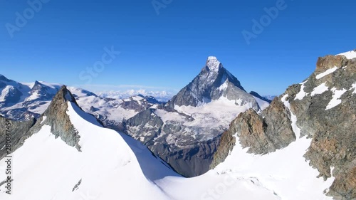 Aerial shot going over mountain pass near Zermatt, Switzerland. Matterhorn summit in background photo