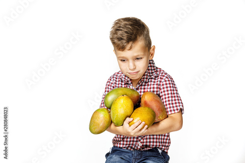 handsome boy in a red shirt with a mango