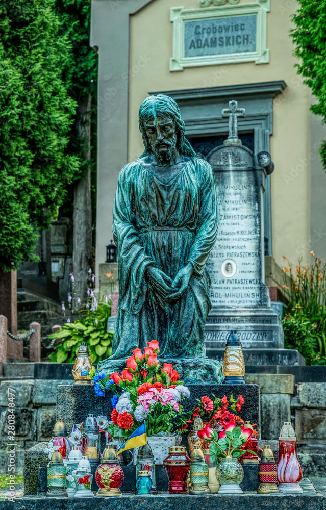 Fototapeta premium Marble statue and an ancient abandoned Gothic cemetery 
