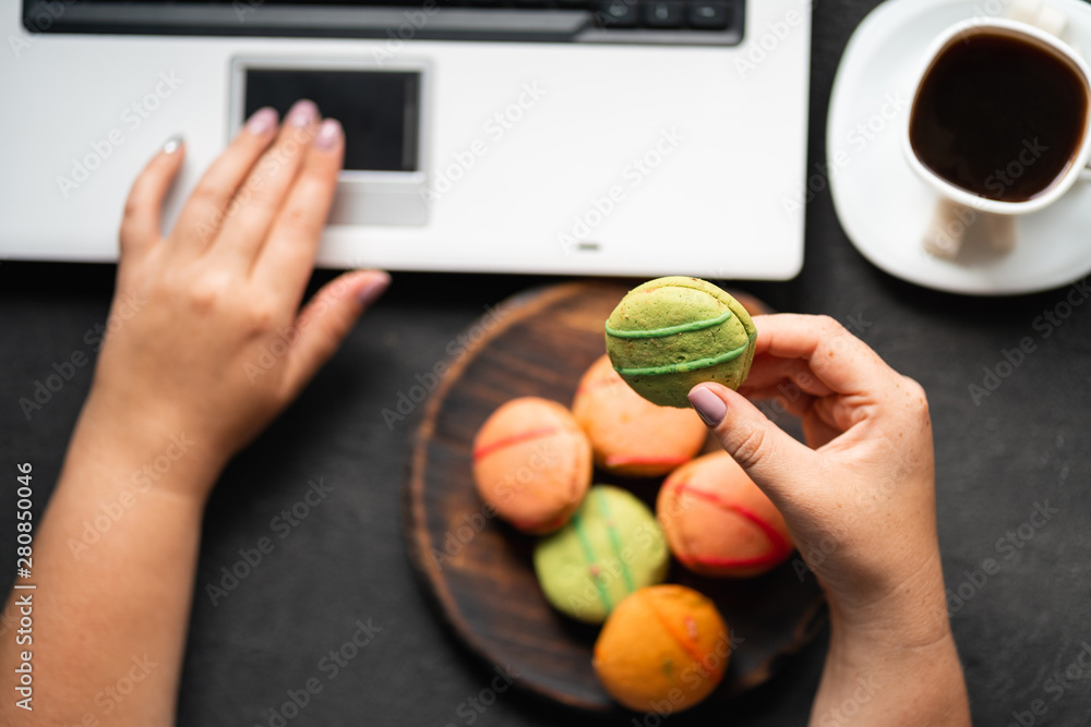 Unhealthy snack at work time. Woman eating cookies and drinking coffee