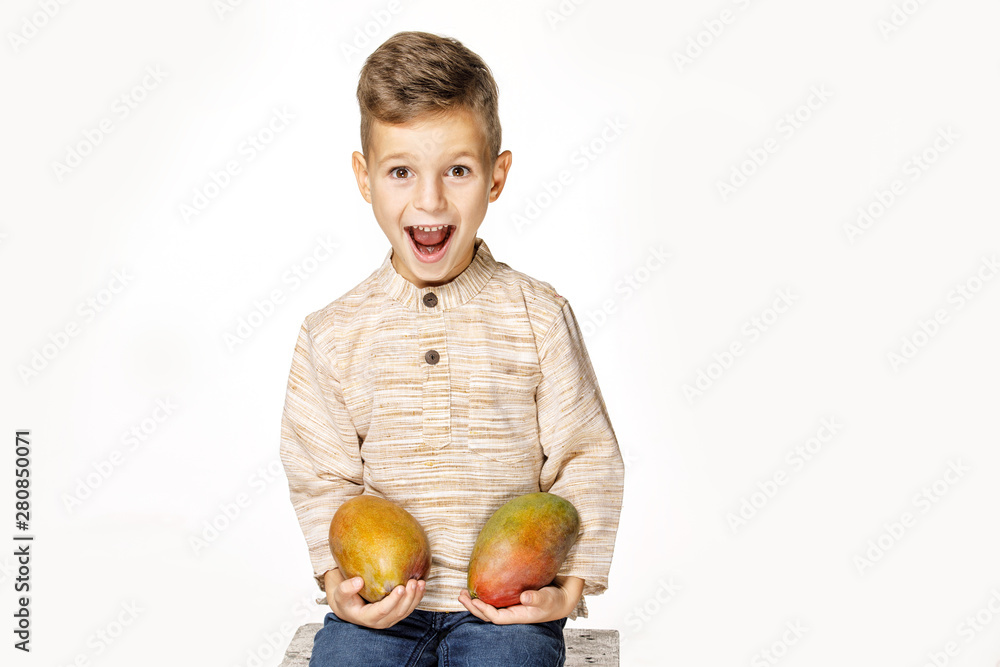 Fototapeta premium handsome pretty boy is holding a mango 