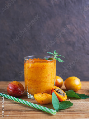 Summer delicious Apricot smoothie in a glass on a wooden background