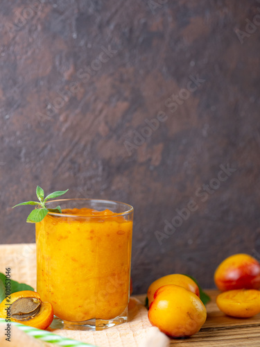 Summer delicious Apricot smoothie in a glass on a wooden background