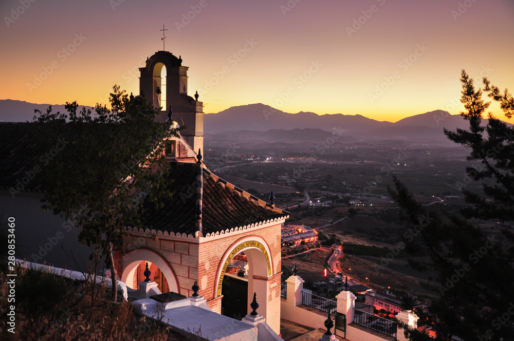 Place of religious worship. Peaceful view of Small chapel in town of Cártama, region of Málaga. Sun setting down behind the mountain hills of Andalucía. Spain
