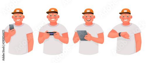 Young man uses various gadgets. The guy is holding a smartphone and tablet, playing video games