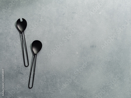 Salad serving utensils and copy space for text or design. Salad serving utensils on gray stone background. Recipe book, diet, salad concept. Copy space for text. Top view or flat lay