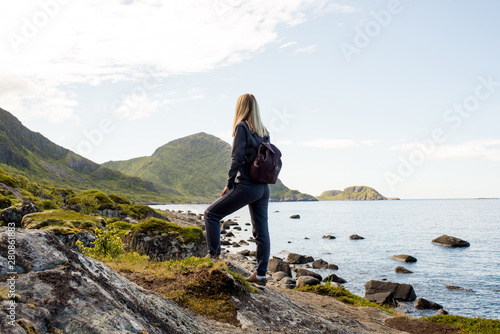 Woman goes on tourist hiking trail along ocean and mountains in Norway. Active recreation, healthy lifestyle. Enjoys scenic view. Beautiful nature. Travel, adventure. Sense of freedom. Explore North © Iuliia Pilipeichenko