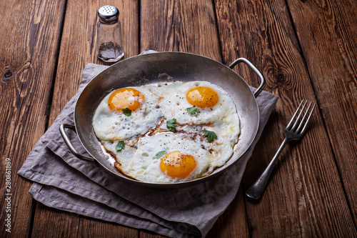 Fried eggs on white wooden background