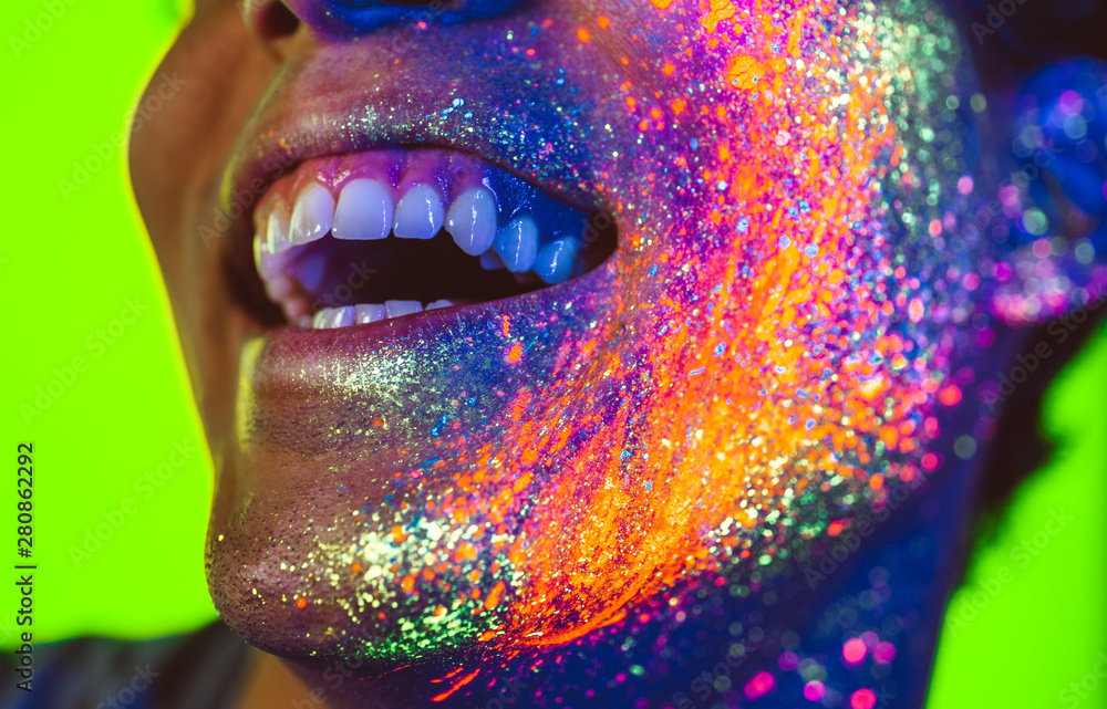 Handsome boy dancing at the rave party with fluorescent paintings on his face Handsome boy dancing at the rave party with fluorescent paintings on his face