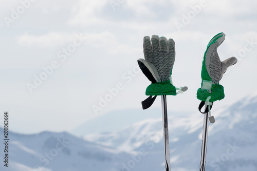 Fotografie Gloves on ski poles and snowy winter mountain
