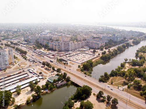 Aerial photography of a cityscape with a river with bridge, a road and a buildings. © Stanislav