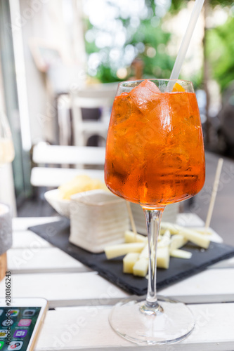 Glass of Aperol Spritz cocktail on the table in restaurant, famous refreshing drink, Italy. photo