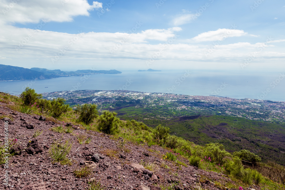 View from Vesuvius volcano in Italy to the coast of sea and city from above, against the sky.