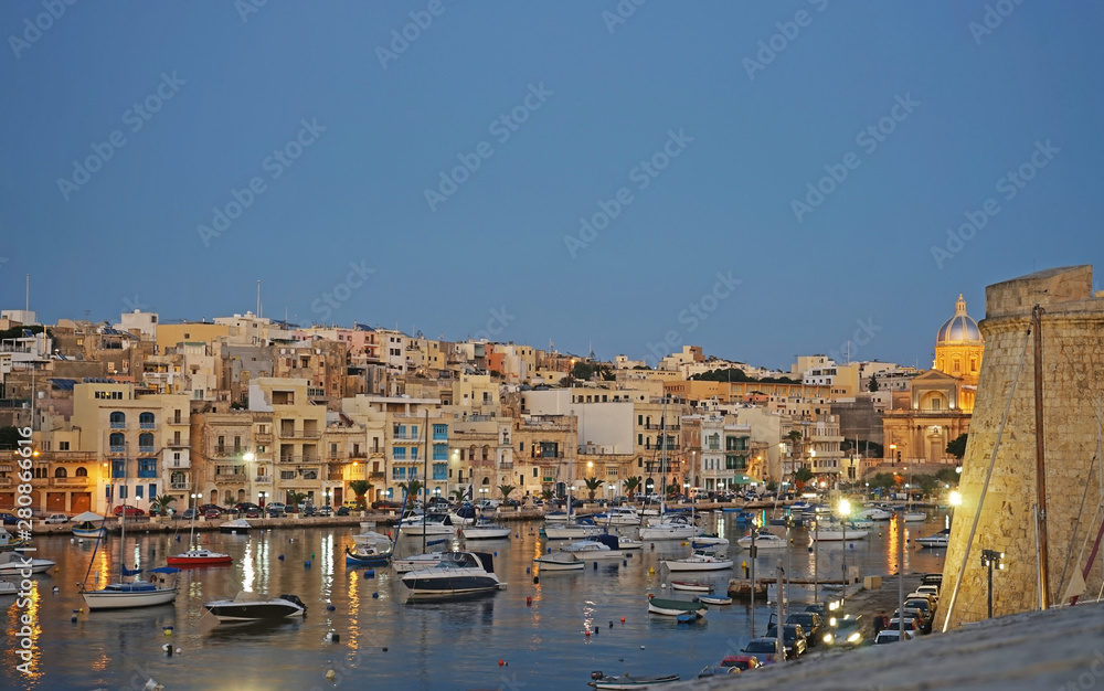 View of Birgu, Malta in the evening, marina and boats, lights. 