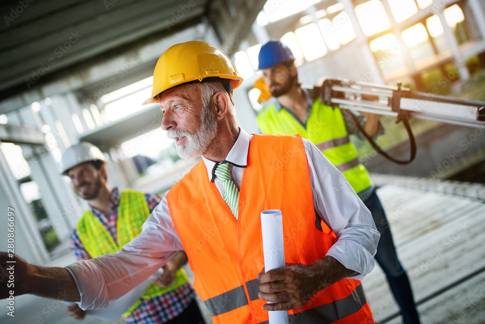 Engineer and construction site manager dealing with blueprints and plans Engineer and construction site manager dealing with blueprints and plans