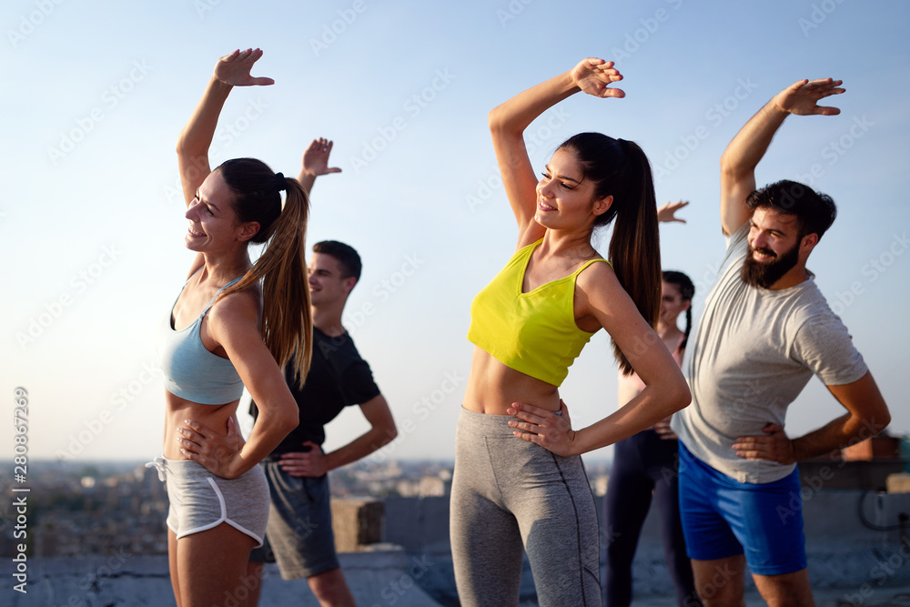 Group of fit happy sporty people exercising outdoors Group of fit happy sporty people exercising outdoors