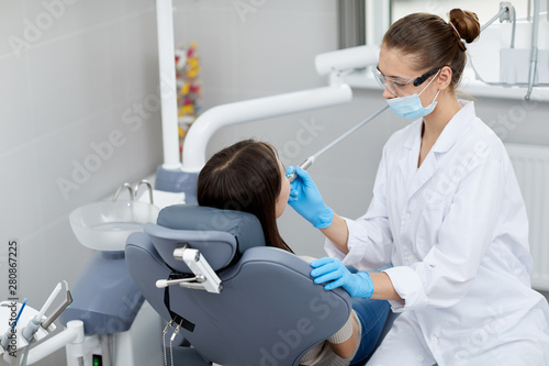 High angle portrait of female dentist examining child in clinic  copy space