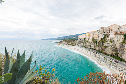 Tropea town and beach coastline of Tyrrhenian Sea with turquoise water, colorful buildings on top of high big rocks, view from Sanctuary church of Santa Maria dell Isola, Calabria, Southern Italy photo