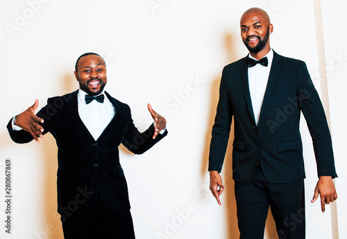 two afro-american businessmen in black suits emotional posing, gesturing, smiling. wearing bow-ties, lifestyle people concept photo