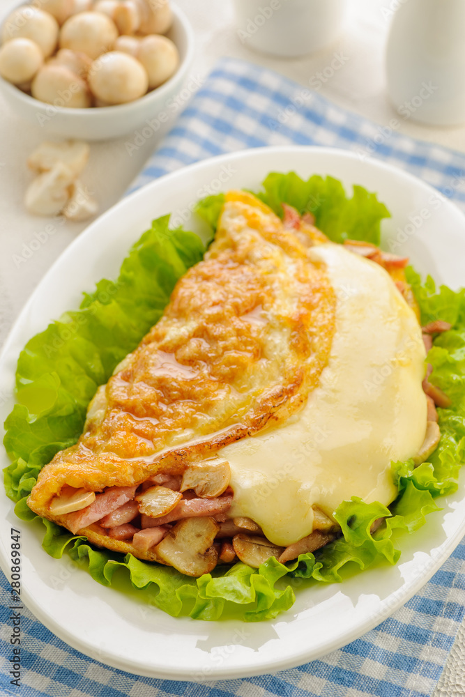 Fried omelet stuffed with ham, mushrooms and cheese