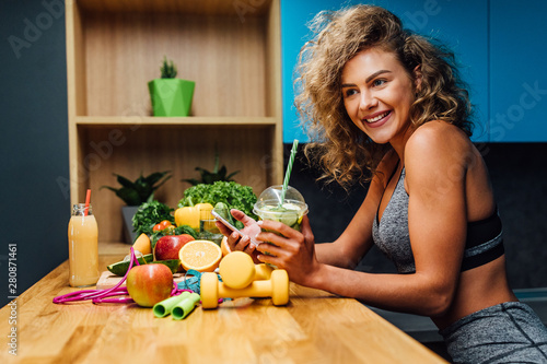 Young woman wearing  top enjoying healthy breakfast, eating fruits, smiling, home kitchen time. photo