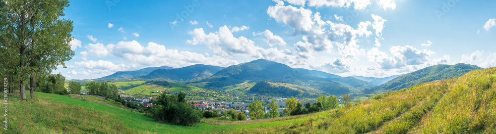beautiful rural area of carpathian mountains. trees and agricultural fields on hills. panoramic landscape in dappled light. forest on the distant ridge. sunny weather with clouds on the afternoon sky - obrazy, fototapety, plakaty 