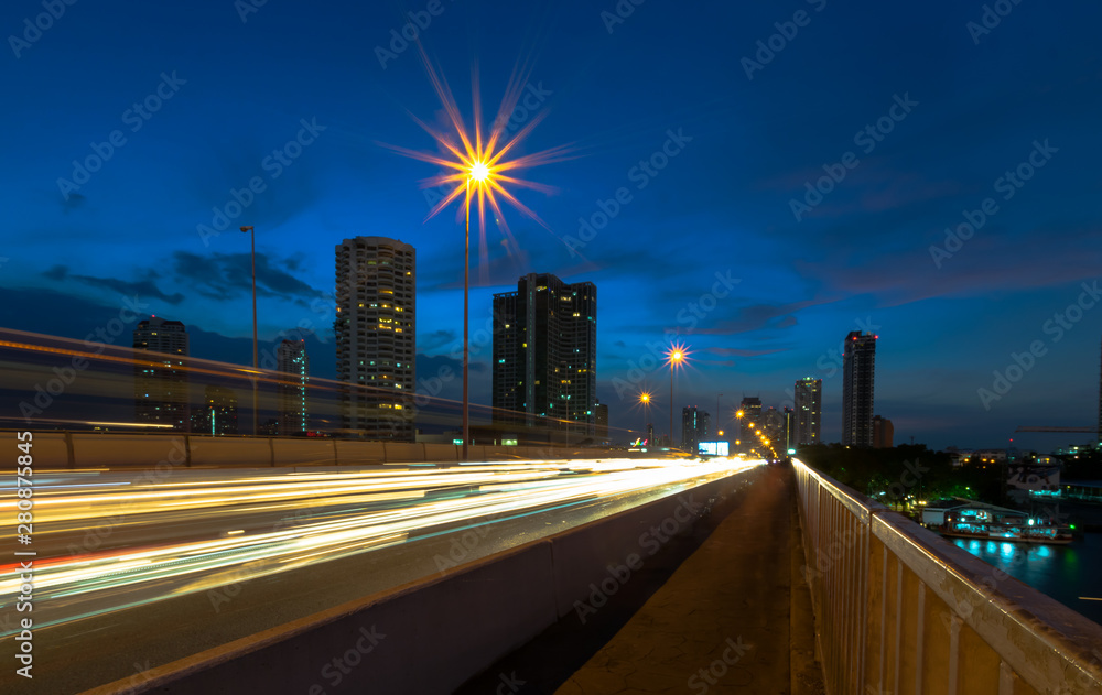 Fototapeta premium Bangkok, Thailand Dec. 1, 2017 : Light trails of car and BTS Sky Train at taksin bridge, Bangkok, Thailand (Traffic jam on bridge Taksin (Sathorn))