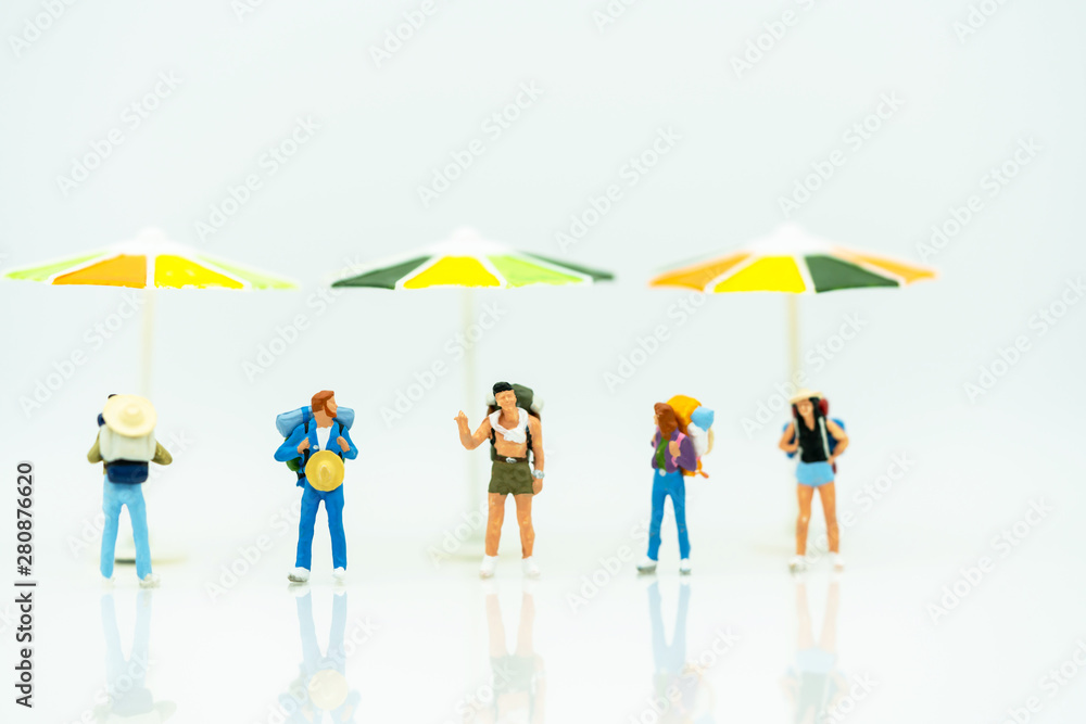 Miniature people: Tourists with backpack standing on the beach. Summer Concept. Miniature people: Tourists with backpack standing on the beach. Summer Concept.
