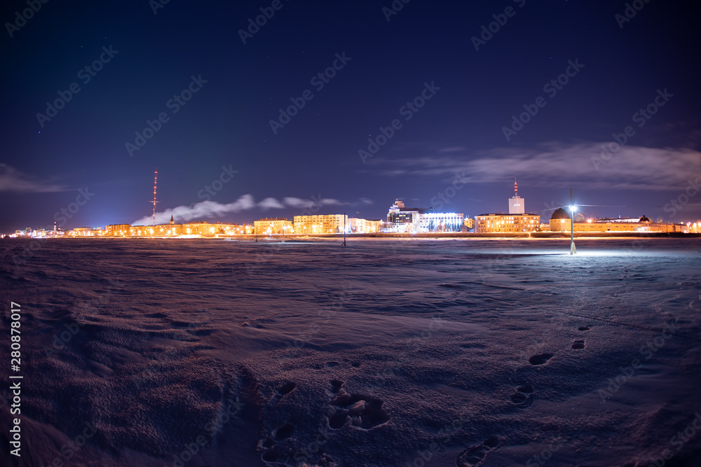 Φωτογραφία Night winter view of the city of Arkhangelsk with the frozen Northern Dvina River hidden under the ice