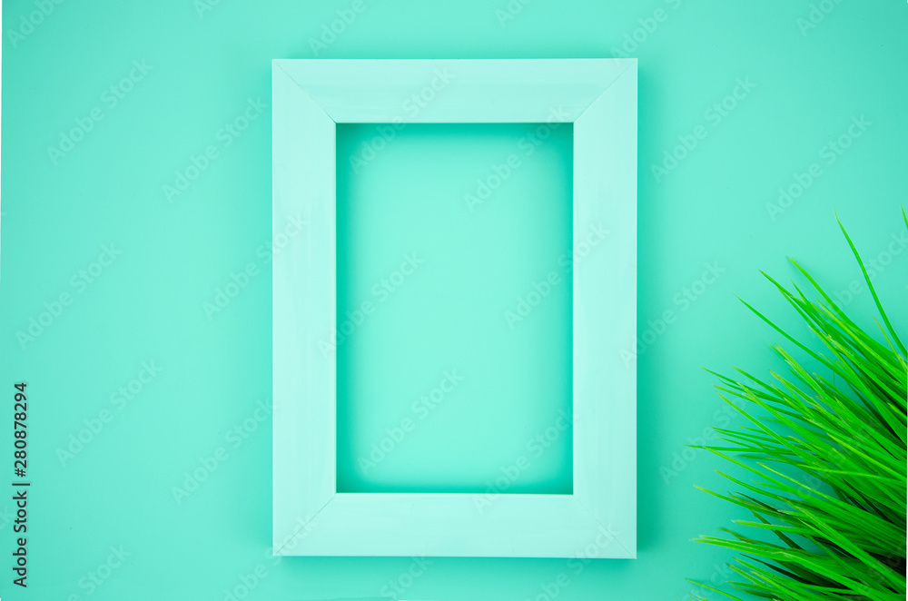 Summer mockup with photo frame and grass on a mint background. Flat lay with copy space Summer mockup with photo frame and grass on a mint background. Flat lay with copy space