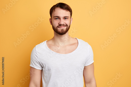 cheerful young cunning handsome being in high spirit , shares impressions, expresses positive emotion. close up photo. isolated yellow background.
