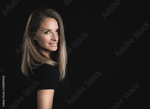 Beautiful middle aged woman on black background with space for text