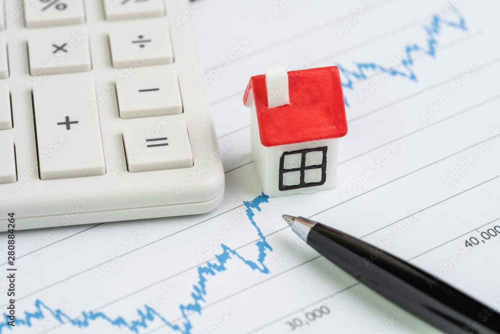 Housing, property or real estate price analysis or calculation concept, miniature house on blue up rising graph with pen and calculator Housing, property or real estate price analysis or calculation concept, miniature house on blue up rising graph with pen and calculator