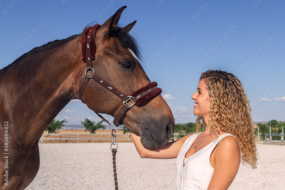 Obraz premium blonde girl stroking a horse
