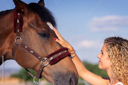 Bild auf Leinwand blonde girl stroking a horse