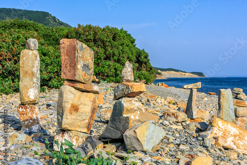 Scenic landscape of Black Sea coast by Bolshoy Utrish village, Anapa, Russia. Stone towers on pebble beach on blue sky sunny summer day. photo