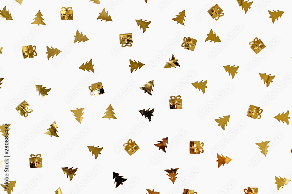 Christmas and new year concept. Shiny confetti in the shape of Christmas trees and gift box isolated on white background. Top view, flat lay composition. Copy space for text or design Christmas and new year concept. Shiny confetti in the shape of Christmas trees and gift box isolated on white background. Top view, flat lay composition. Copy space for text or design