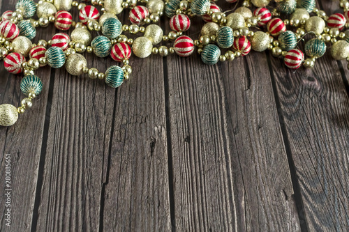New year concept. Colorful Christmas beads on dark wooden background. Top view, flat lay composition.
