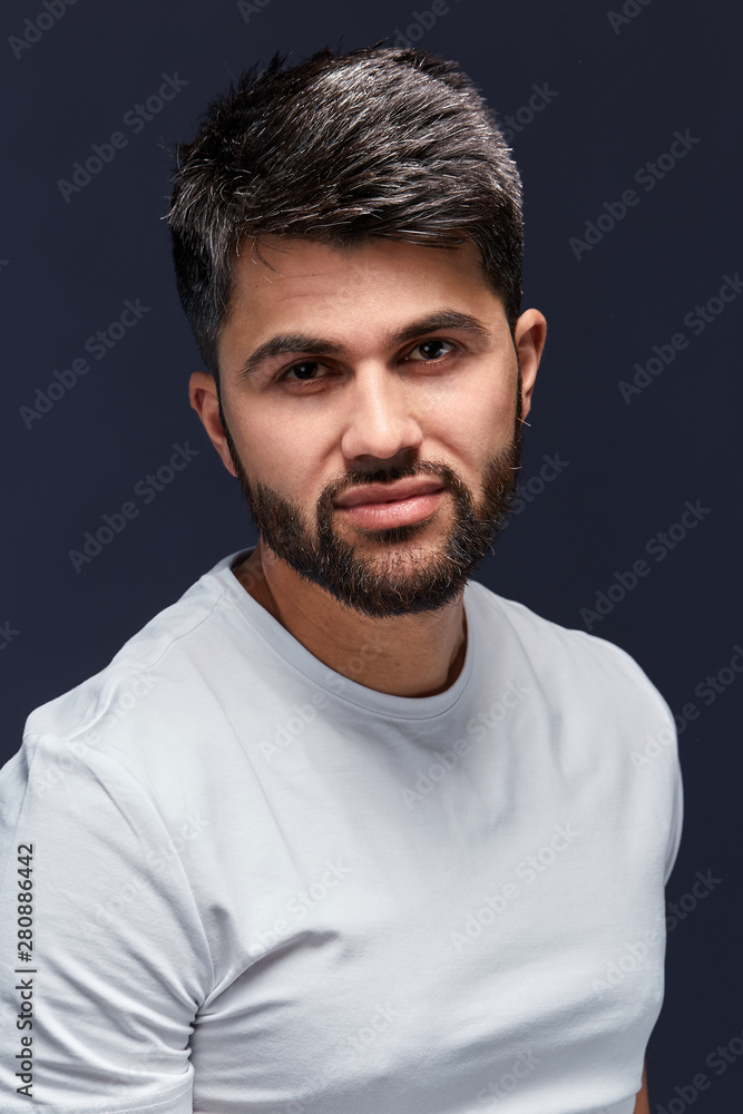 attractive cool sexy Arab guy posing to the camera, isolated black background, lifestyle, free time, spare time