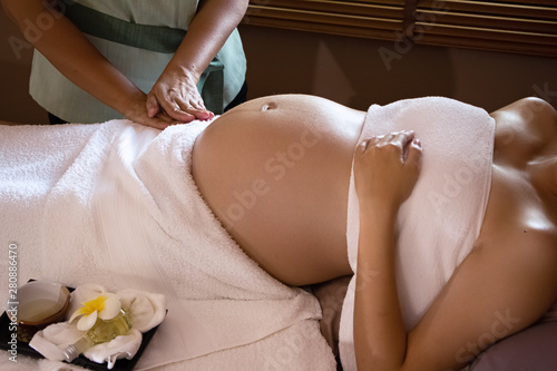 The therapiist massaging pregnant woman,for treat and relax program,at spa therapy