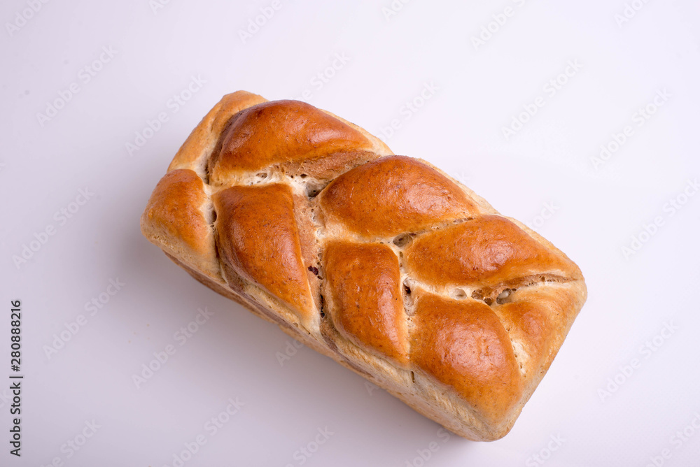 White bread baked from above in the form of a pigtail. Baking on a white background