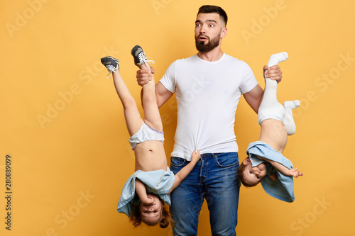 puzzled scared man doesn't know how to look after kids. guy doesn't know how to calm down naughty children. new method of upbringing. close up photo. isolated yellow background photo