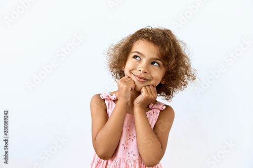 Dreamy,pleased, thinking emotion . Wish concept. Little African American girl face portrait on white backgound.