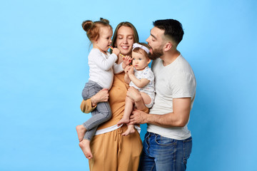 Happy family eating lollipop while standing over blue background. studio shot. close up portrait. happiness, love,strong relationship