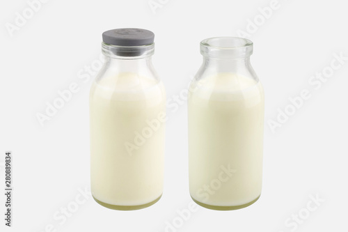  Fresh milk in a transparent bottle with and without lid, isolated on white background, Perspective