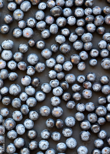 Ripe organic blueberries on a black surface  top view. Summer berry. Flat lay  overhead  from above.