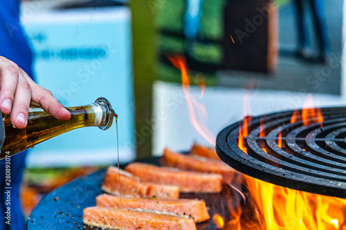 The chef prepares delicious fillet of salmon and adding oil. Closeup of a fresh fillet of salmon