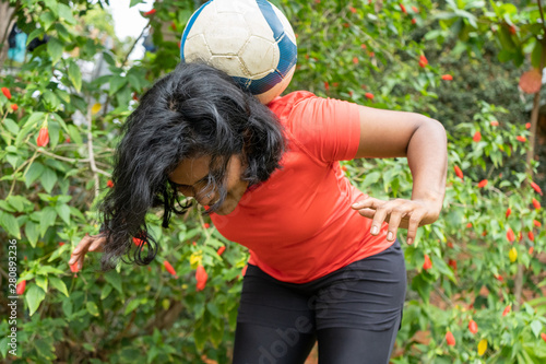 beautiful sporty indian female athlete woman playing football tricks