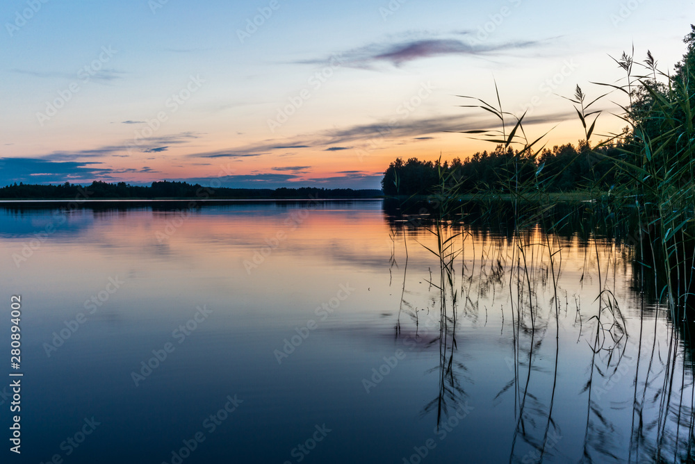 Fototapeta premium Reflections on the calm waters of the Saimaa lake in Finland at Sunset - 9